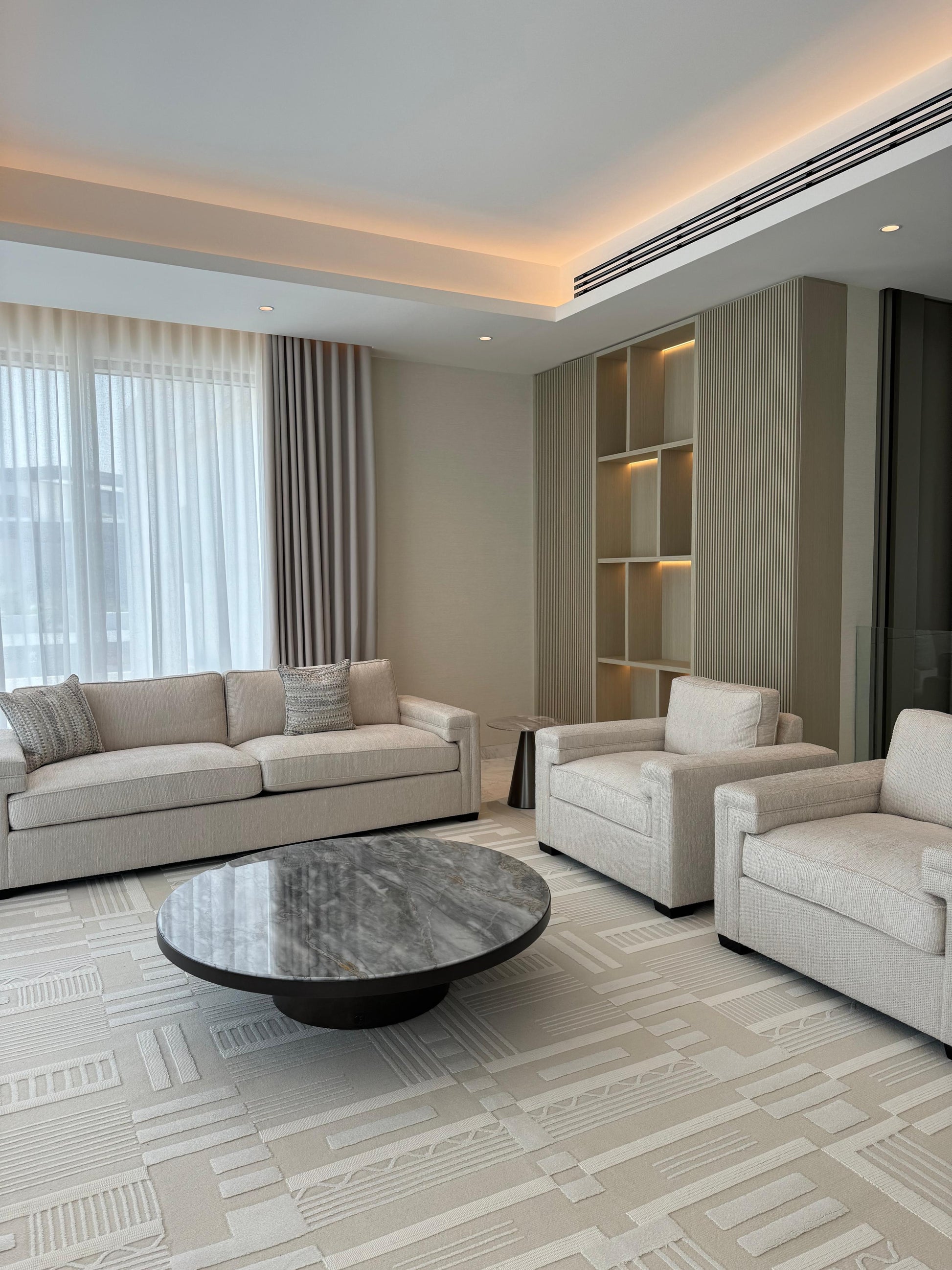 Modern living room with beige sofa, coffee table, and decorative elements.