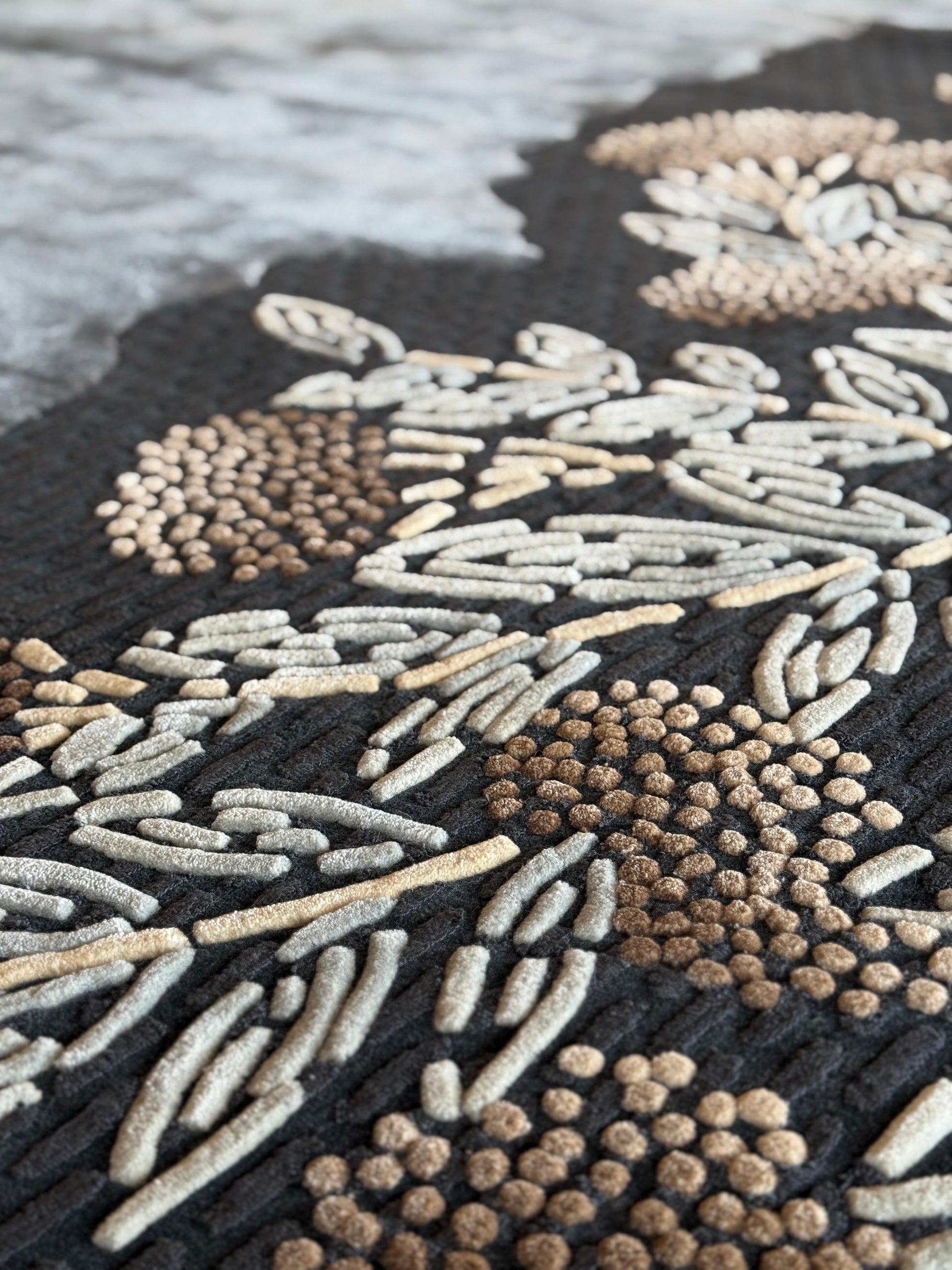 Close-up of a textured rug with floral patterns in neutral colors.