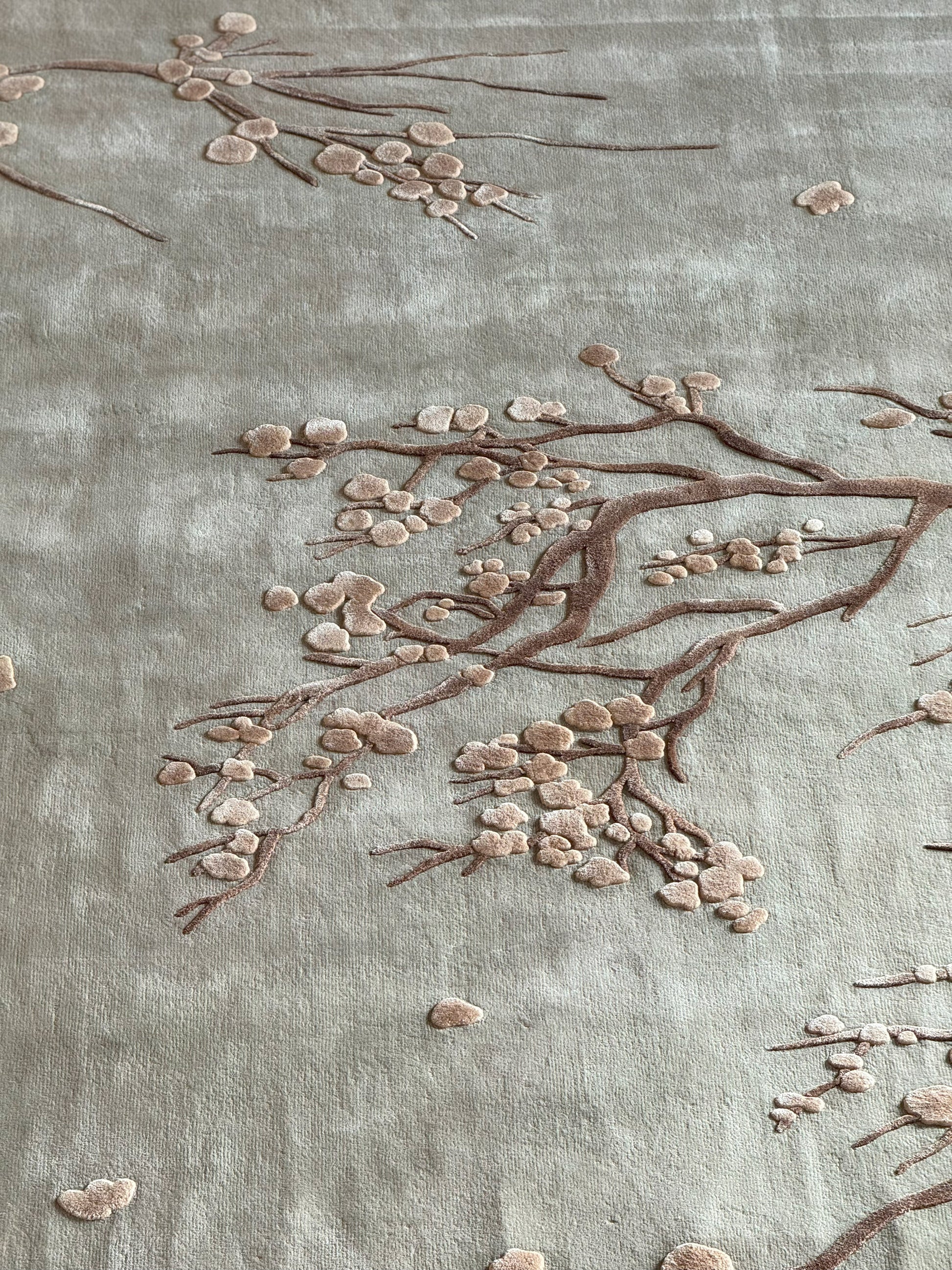Close-up of embroidered floral design on fabric with a soft green background