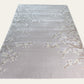 Gray rug with floral patterns on a white background