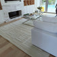 Modern living room with white sofa, glass coffee table, and marble fireplace.