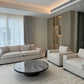 Modern living room with beige sofa, coffee table, and decorative elements.