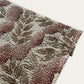 Close-up of a textured rug with floral patterns on a white background
