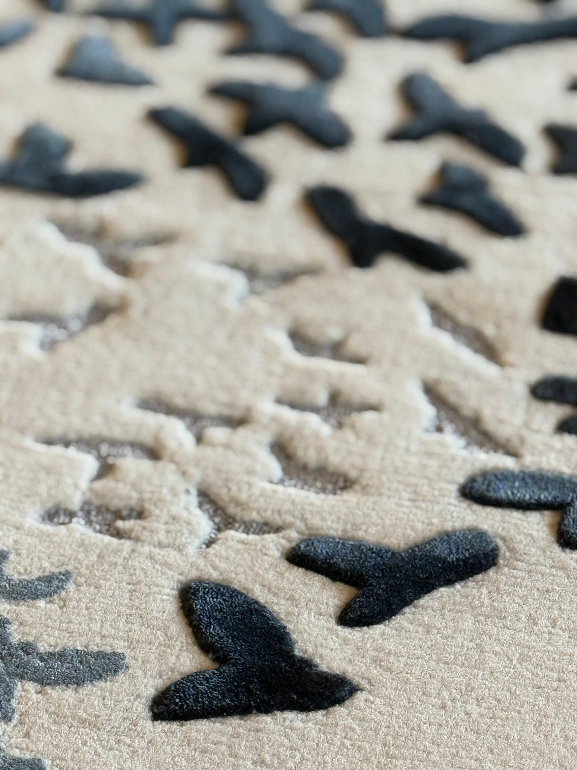 Close-up of textured surface with black butterfly shapes