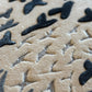 Close-up of textured beige and black surface with butterfly patterns