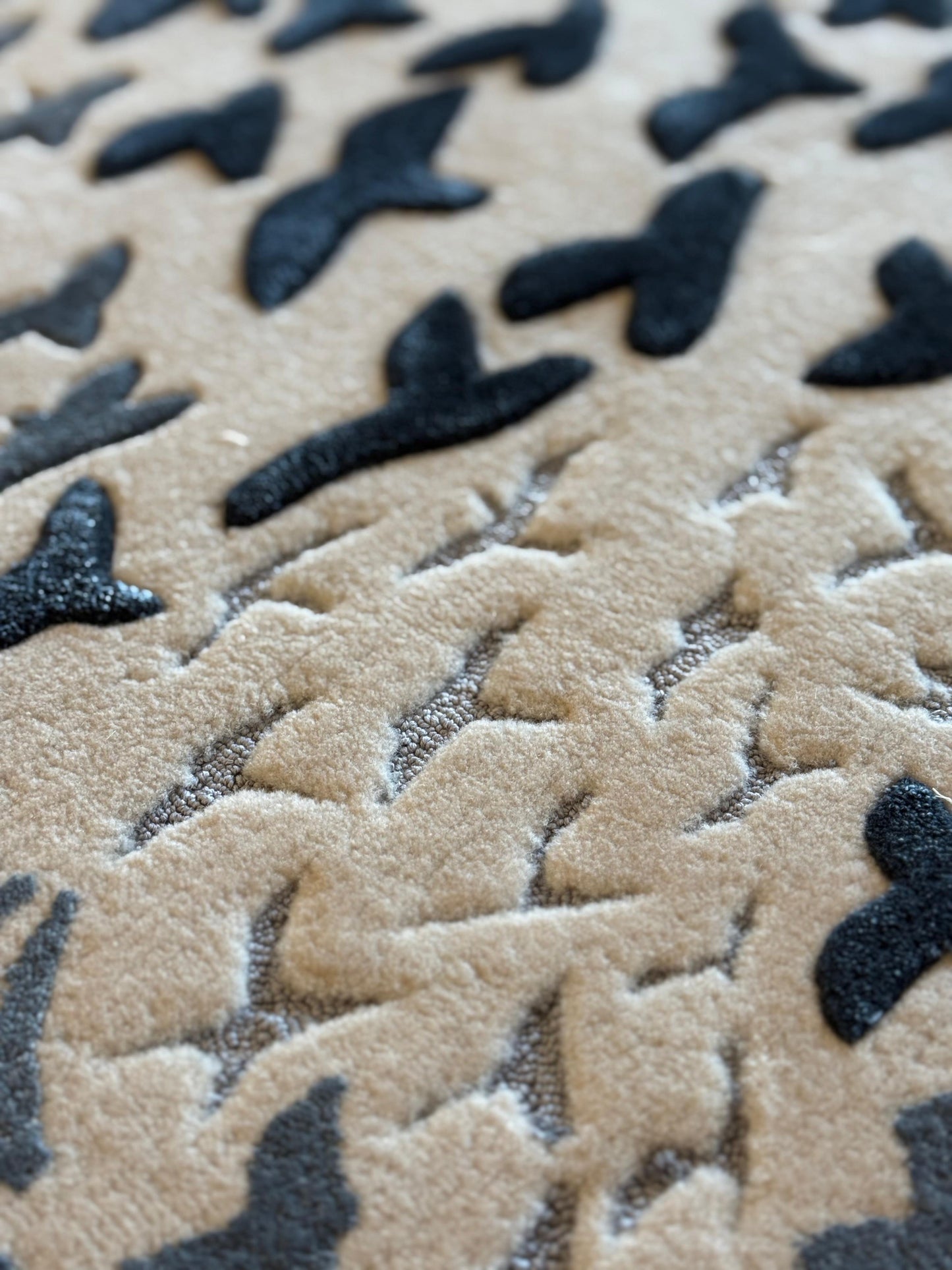 Close-up of textured beige and black surface with butterfly patterns