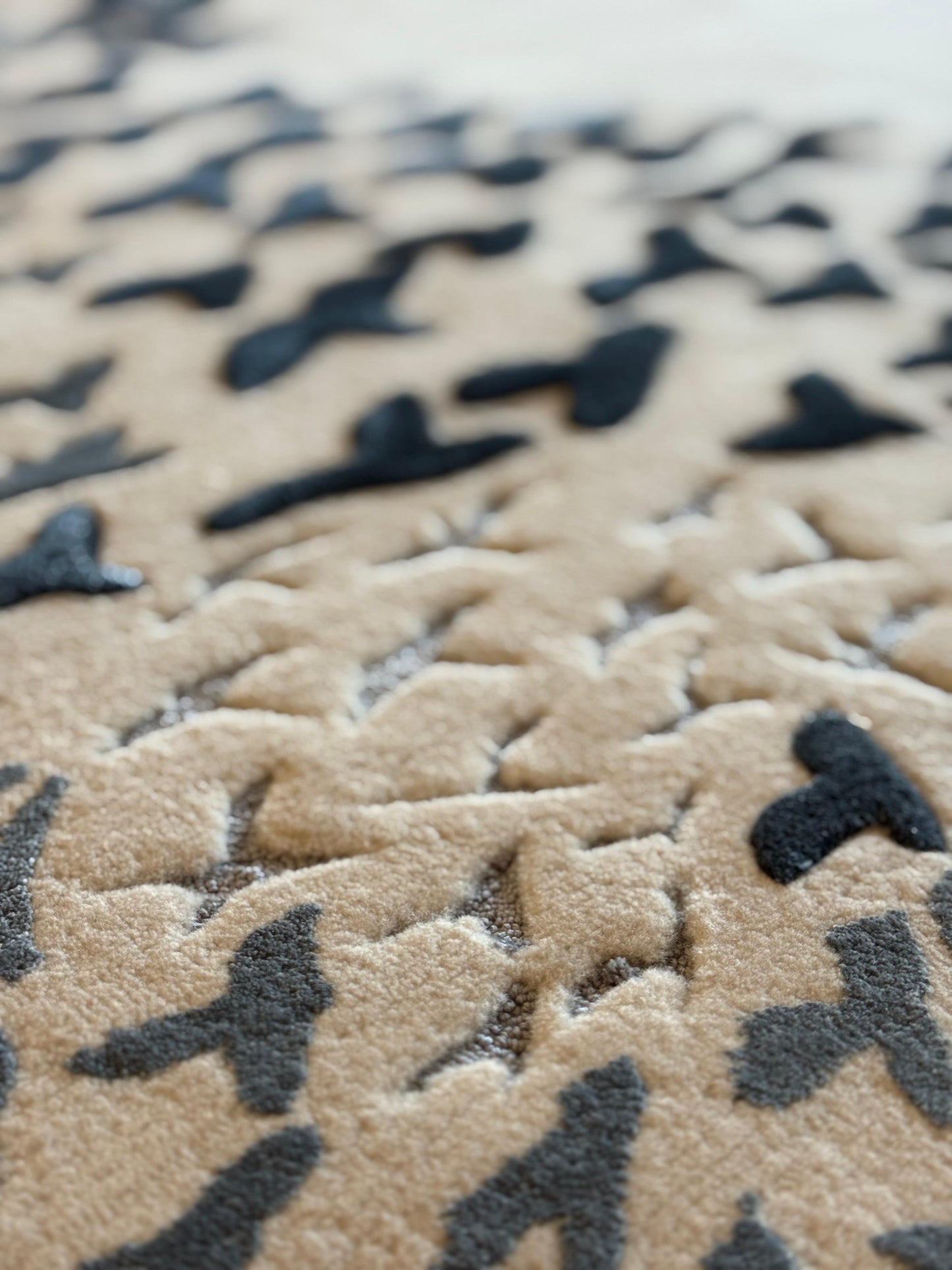 Close-up of a camouflage-patterned rug with black and beige colors.