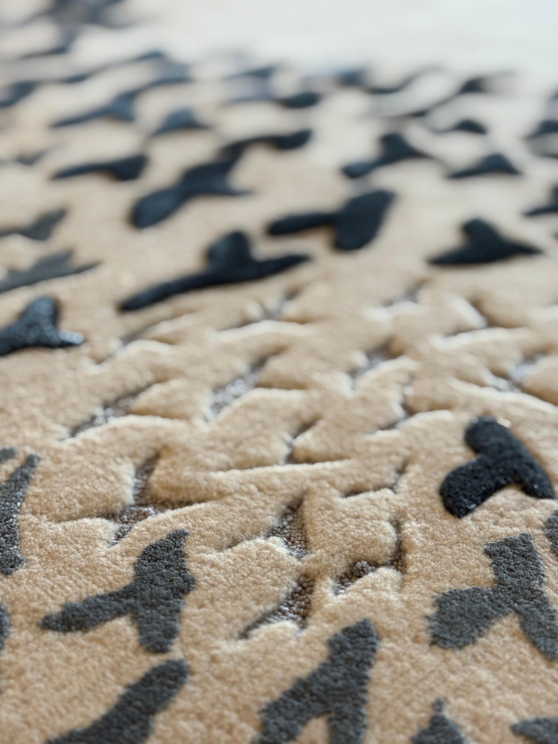Close-up of a camouflage-patterned rug with black and beige colors.