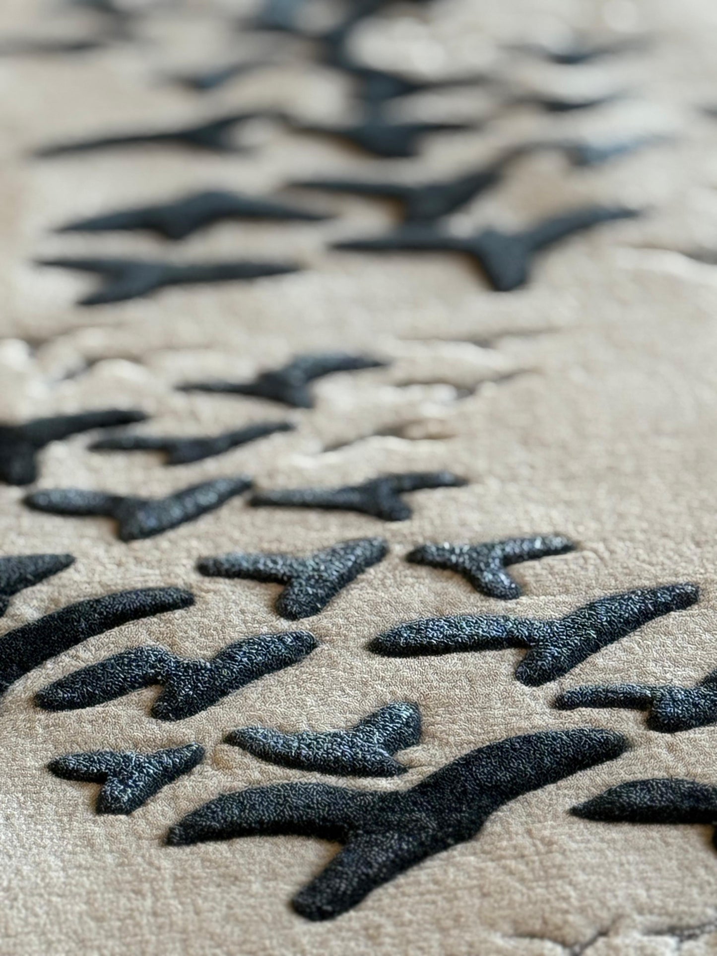 Close-up of textured fabric with black pattern on beige background