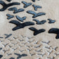 Pattern of black birds on a beige sand background