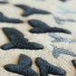 Close-up of black shark-shaped objects on a beige surface