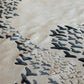 Close-up of a textured surface with black leaf-like patterns on a beige background