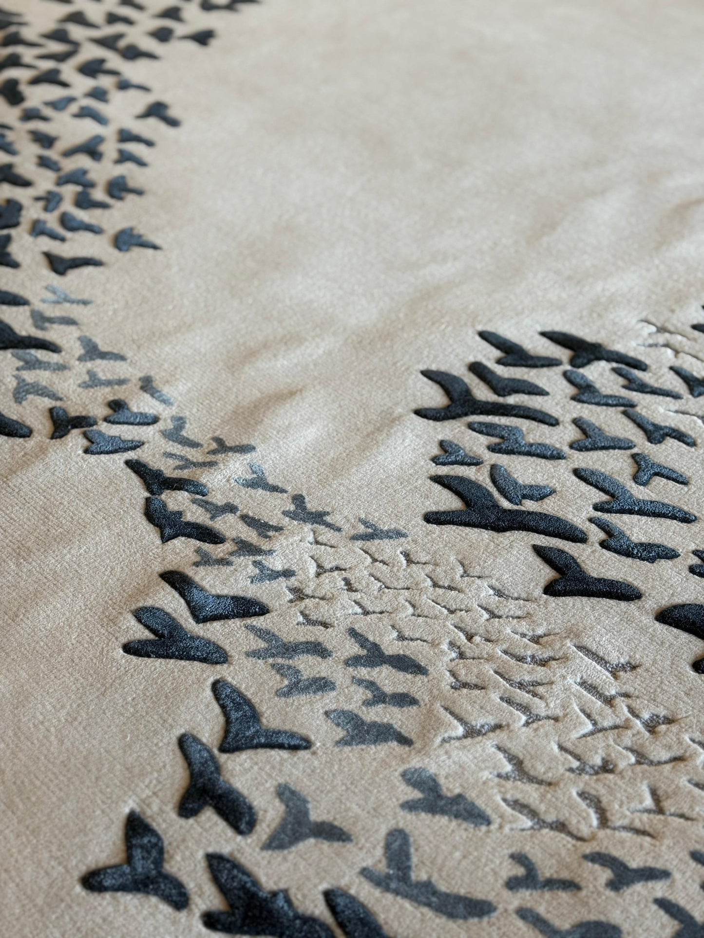 Close-up of a textured surface with black leaf-like patterns on a beige background
