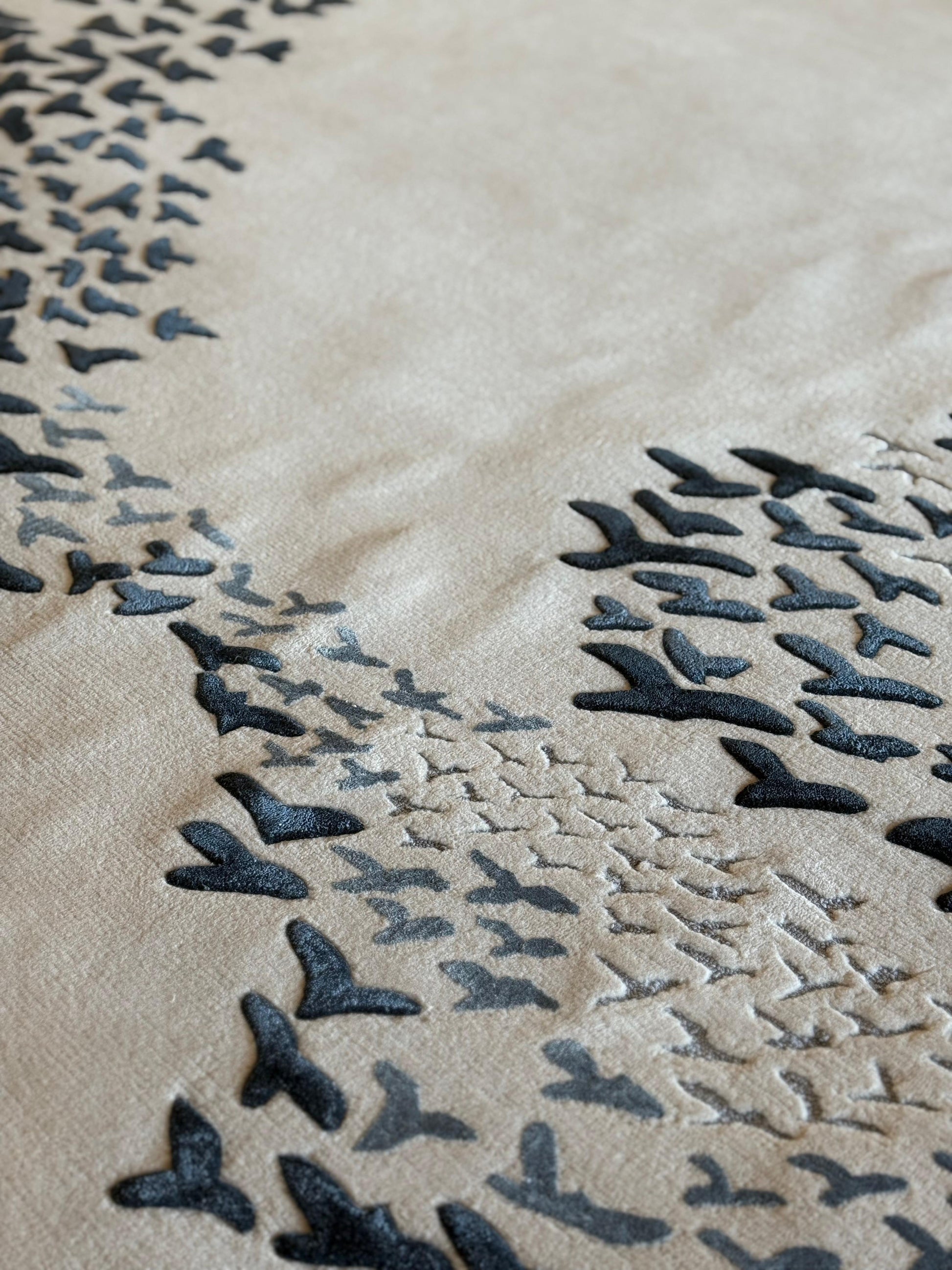 Close-up of a textured surface with black leaf-like patterns on a beige background